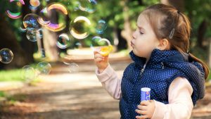 ein Kind pustet Seifenblasen