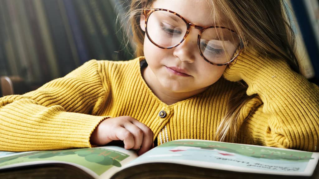 Kind schaut sich vertieft ein Buch an